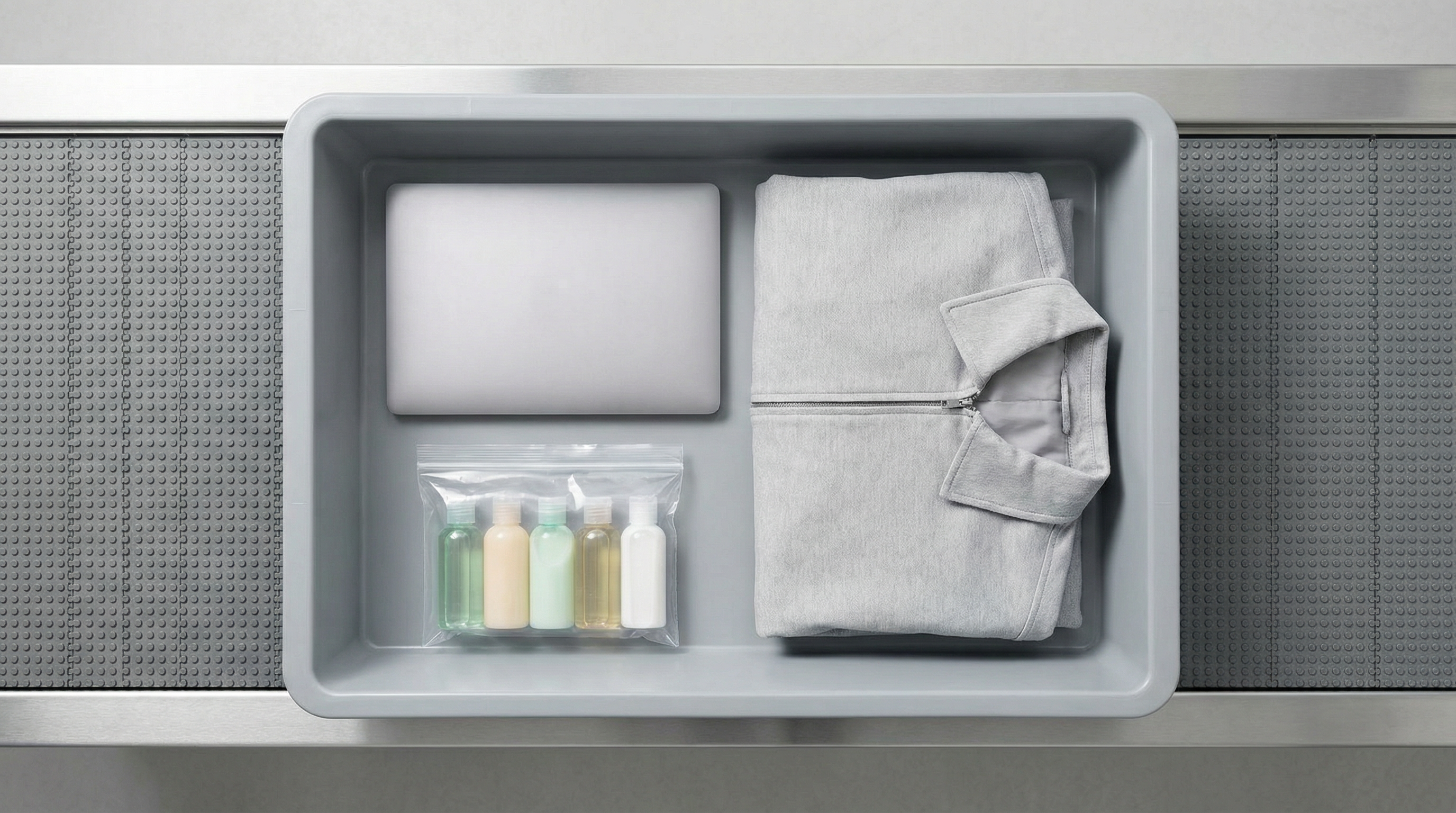 Dica: Um tabuleiro de segurança de aeroporto muito bem organizado, com um portátil fora da capa e um saco transparente zip-lock com pequenos frascos de líquidos no topo